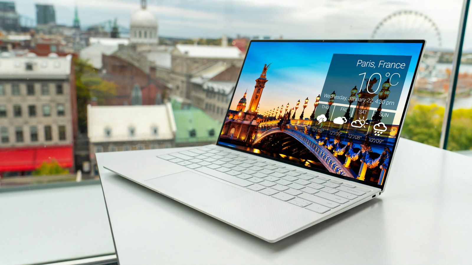 An open refurbished laptop on a white desk